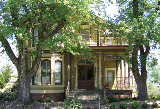Two-story Victorian house with trees in front